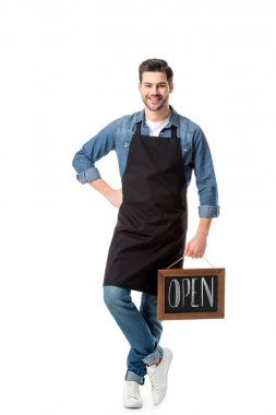 smiling young waiter with open blackboard isolated on white clipart