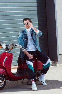 vintage kırmızı scooter üzerinde şık eski okul giysileri yakışıklı adam