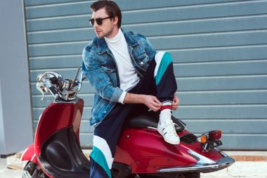 vintage kırmızı scooter üzerinde oturan şık giysiler içinde yakışıklı genç