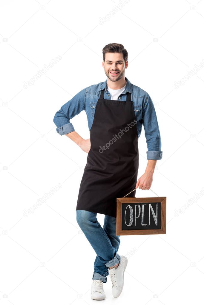 smiling young waiter with open blackboard isolated on white