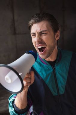 angry young man in vintage windcheater shouting with loudspeaker clipart