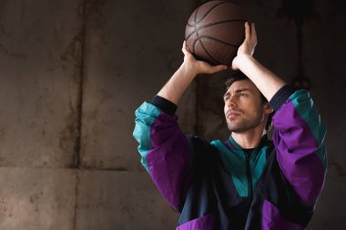handsome young man in vintage windcheater throwing basketball ball clipart