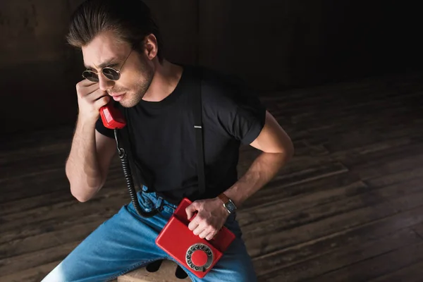 シャツとサスペンダー レトロな有線赤い電話で話しでハンサムな若い男のハイアングル — ストック写真