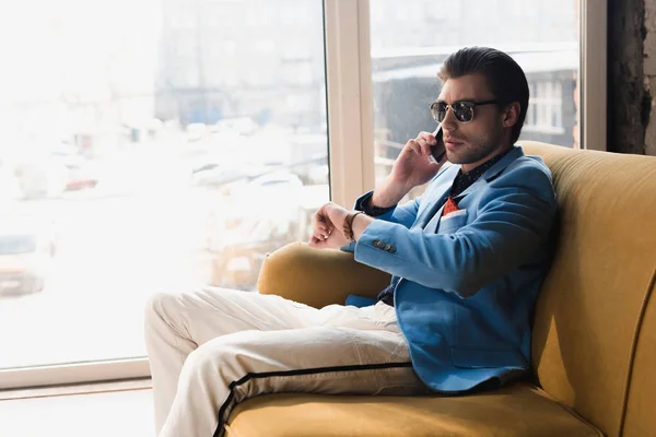 Handsome Young Man Talking Phone While Sitting Couch Looking Watch — Stock Photo, Image