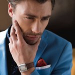 Szczegół portret zadumany młodzieniec w szykowny garnitur z zegarek na rękę