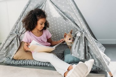 Afro-Amerikan çocuk okuma kitabı chihuahua köpek ile tarafından teepee evde
