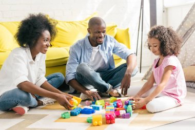 Afro-Amerikan aile renkli blokları ile birlikte evde katta oynama gülümseyen