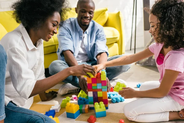 家の床にカラフルなブロック一緒に遊んで幸せなアフリカ系アメリカ人の家族 — ストック写真