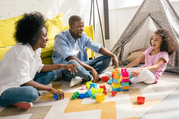 家の床にカラフルなブロック一緒に遊んで幸せなアフリカ系アメリカ人の家族 — ストック写真