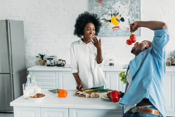 自宅のテーブルで新鮮な野菜とアフリカ系アメリカ人のカップル  — 無料ストックフォト