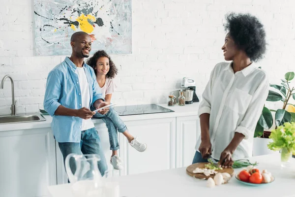 アフリカ系アメリカ人の女性が自宅のキッチンでカウンターの後ろに家族と一緒に朝食を調理の選択と集中 — ストック写真