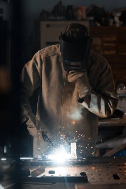 Kaynakçı ile metal fabrikasında çalışan koruma maskesi önden görünümü 