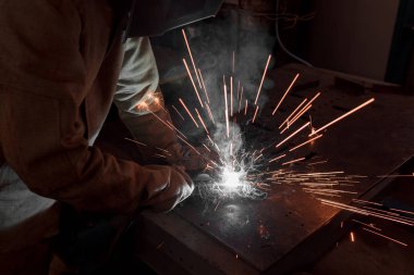 cropped image of welder in protection mask working with metal at factory  clipart