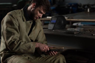 metal parça tarafından fırça Fabrikası'nda temizlik üniformalı erkek işçi