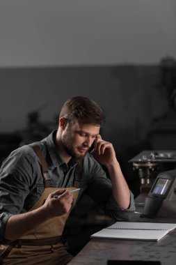 smartphone üzerinde konuşmak ve boş ders kitabı masada oturan işçi 