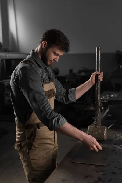 Vista Lateral Del Joven Trabajador Masculino Martillando Parte Metal Fábrica — Foto de Stock