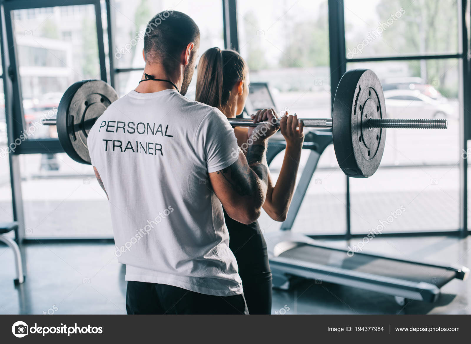 Männlicher Personal Trainer Hilft Sportlerin Bei Übungen Mit Langhantel ...