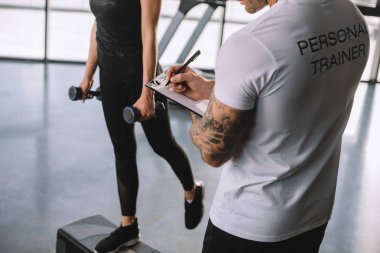 erkek kişisel antrenör Pano ve genç sporcumuz adım vasıl jimnastik salonu dumbbells ile aerobik egzersiz yapıyor yazma Resim kırpılmış