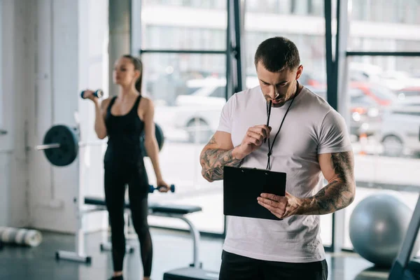 Personal Trainer Masculino Com Prancheta Jovem Esportista Exercitando Com Halteres — Fotografia de Stock