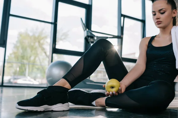 Unga Idrottskvinna Sitter Gym Golv Med Apple Hand Gym — Stockfoto