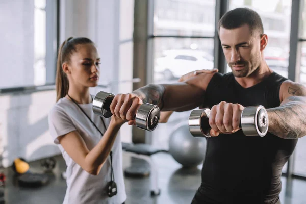 Female Personal Trainer Helping Sportsman Exercises Dumbbells Gym — Stock Photo, Image