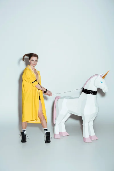 Pria Bergaya Dengan Jas Hujan Kuning Berdiri Dengan Mainan Unicorn — Stok Foto