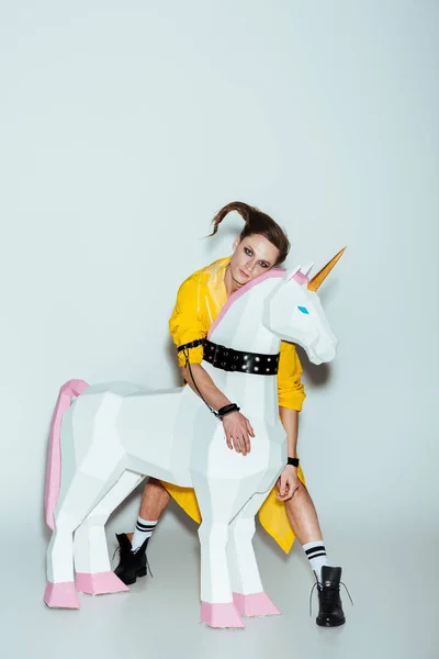 Elegant Man Hairstyle Yellow Raincoat Standing Hugging Big Unicorn Toy — Stock Photo, Image