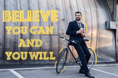 Tek kullanımlık fincan kahve ile sokakta bisikletle eğilerek ile işadamı gülümseyen inanıyorum yapabilirsin ve yapacaksın