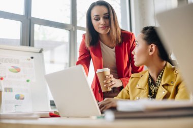 Işık çalışma alanı içinde laptop ile tabloya göre projede çalışan çeşitli iş kadınları
