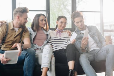 Çeşitli iş takım ışık çalışma alanında smartphone ekranında arıyor