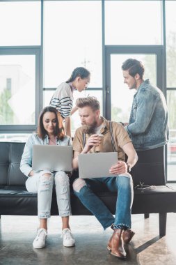 Dizüstü bilgisayarlarda çalışan ve modern ışık office projesinde tartışırken başarılı iş adamları
