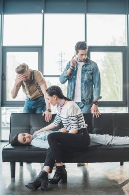 Erkek ve kadın kanepe Office yatan genç kadın bayıldı hakkında endişeli