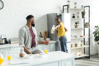 Afro-Amerikan kız erkek mutfak at şişe süt veren