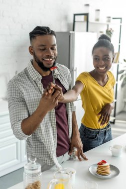 Afrika kökenli Amerikalı çift çatal mutfak at üzerinde çilek ile gülümseyen