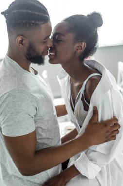 mutfak kız öpüşme gülümseyen Afro-Amerikan erkek yan görünüm