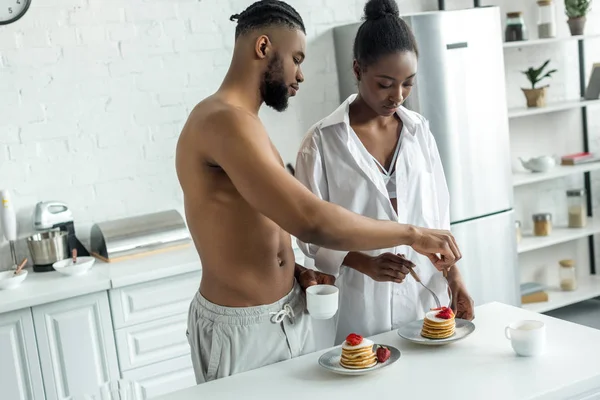 非洲裔美国人夫妇吃煎饼早餐在厨房 — 免费的图库照片