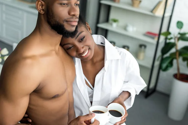 Pareja Afroamericana Abrazando Sosteniendo Tazas Con Café Cocina — Foto de Stock