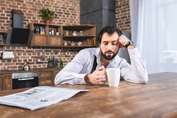 Samotnik Przystojny Biznesmen Siedząc Filiżanką Kawy Śpiąca Przy Stole Kuchni — Zdjęcie stockowe