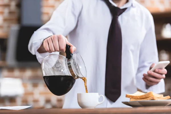 Cropped Image Loner Businessman Pouring Coffee Holding Smartphone Kitchen — Free Stock Photo