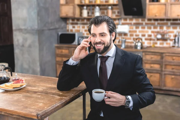 Bonito Solitário Empresário Falando Por Smartphone Segurando Xícara Café Cozinha — Fotografia de Stock