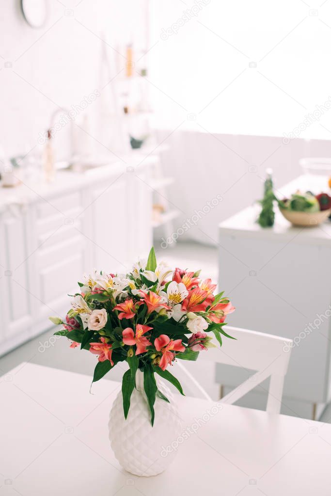 close up view of bouquet of flowers in white vase on table at kitchen 