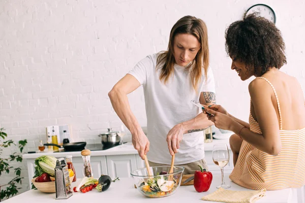 Vista Lateral Sonriente Mujer Afroamericana Disparando Preparación Ensalada Por Novio — Foto de stock gratis