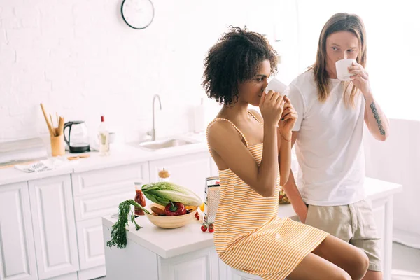 Pareja Joven Interracial Beber Café Tazas Blancas Cocina — Foto de stock gratuita