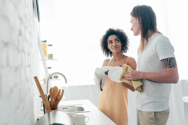 Pareja Joven Multicultural Lavando Platos Mirándose —  Fotos de Stock