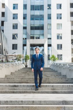 yürüyen merdivenlerden inip, iş bölgesinde şık genç işadamı