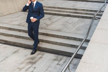 merdivenlerden aşağı giderken telefonla konuşmaya başladın işadamı kahve ile şık elbiseli kırpılmış atış
