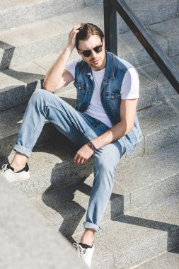 merdivenlerde oturan ve uzak seyir yakışıklı delikanlı
