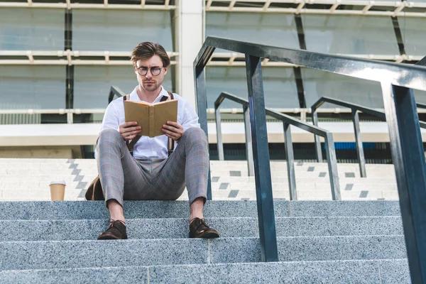 Vista Inferior Del Joven Guapo Con Taza Papel Libro Lectura — Foto de Stock