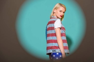 denim ceket Amerikan bayrağı desenli mavi zemin üzerinde poz şık genç kadın yan görünüm