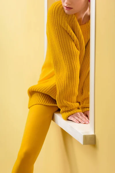 Przycięte Strzał Stylowe Kobiety Żółty Sweterek Rajstopy Siedząc Dekoracyjne Okno — Zdjęcie stockowe